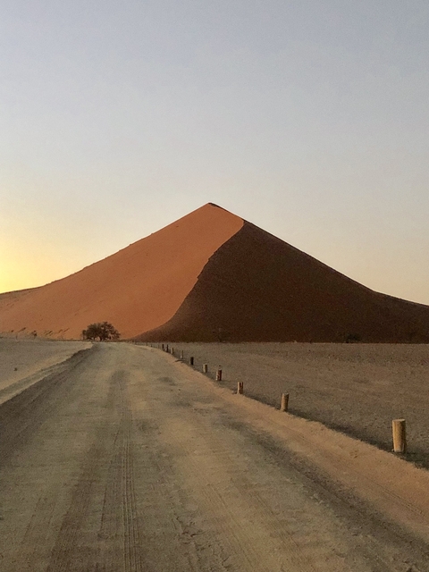 Massive sand dune in the desert during sunset.