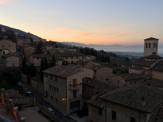 Historic town at sunset with stone buildings.