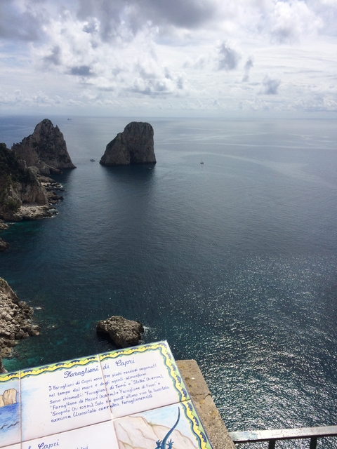 Coastal landscape with rocky formations and boats.