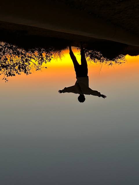 Person silhouetted against a colorful sunset.