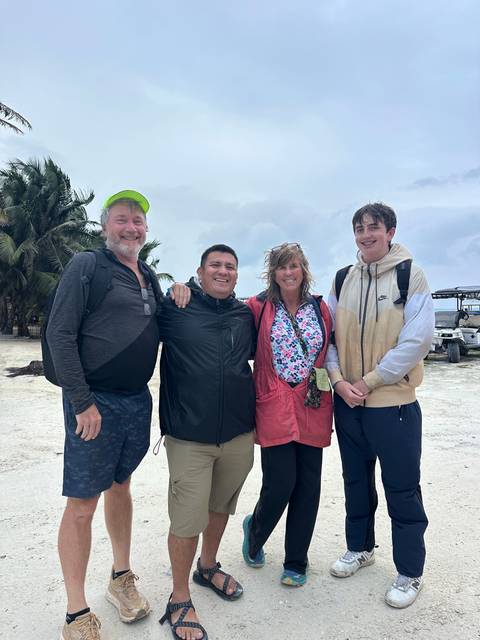 Group of people posing on a beach.