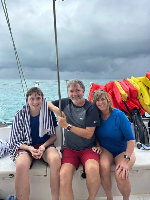 Family on a boat with life jackets.