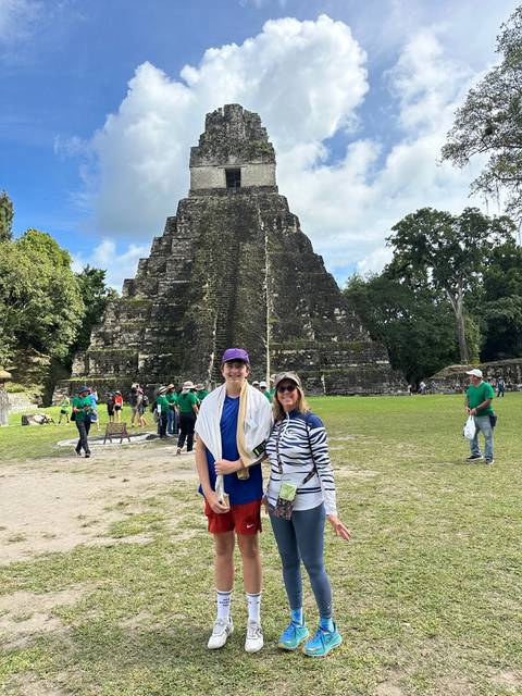 People standing in front of a pyramid.