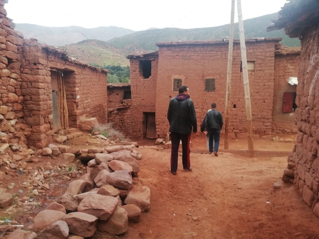 A rural village with stone houses and people walking.