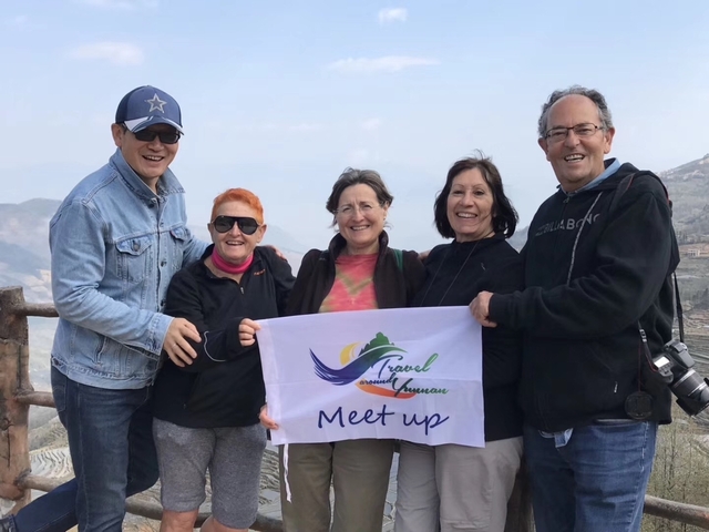       Group of people holding a 'Meet up' banner, smiling at the camera.
  