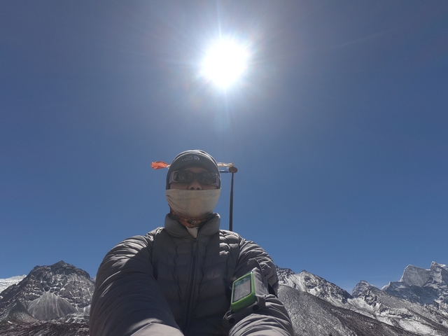       Man in warm clothing with a mountain peak behind.
  