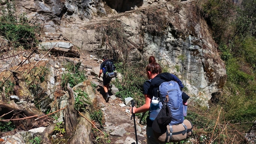       Hikers on a rugged path in a mountainous area.
  