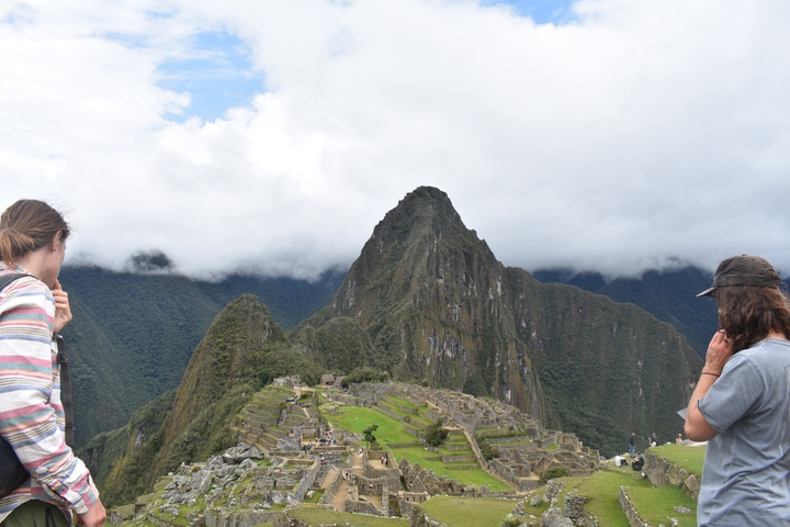 People viewing Machu Picchu with mountain background