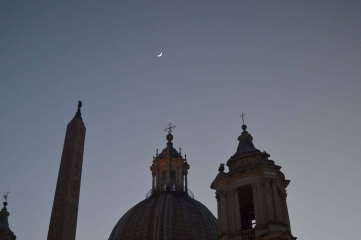 Silhouette of domed building and obelisk against a twilight sky