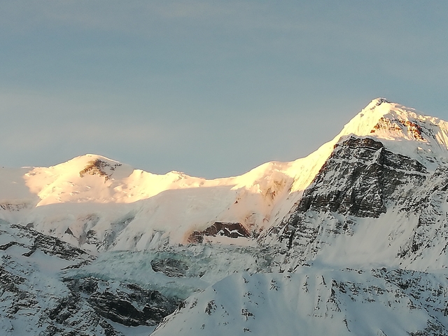       Sunlight hitting snowy mountain peaks
  