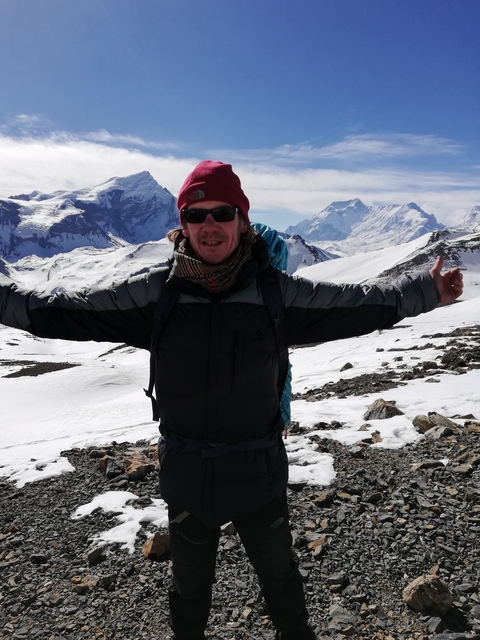       Person celebrating in snowy mountains with prayer flags
  