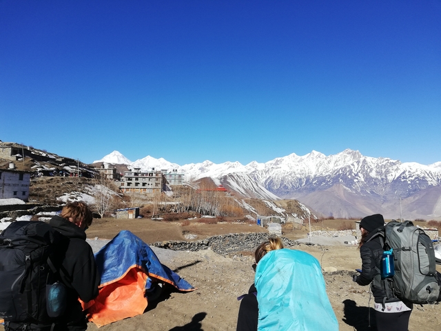       Hikers passing through a mountainous village
  