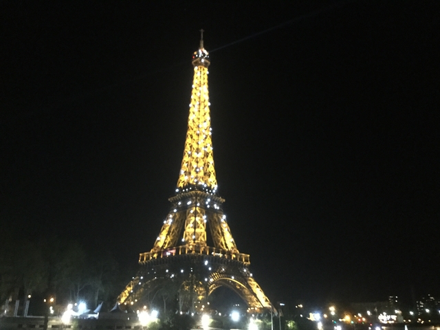 Eiffel Tower illuminated at night against the dark sky.