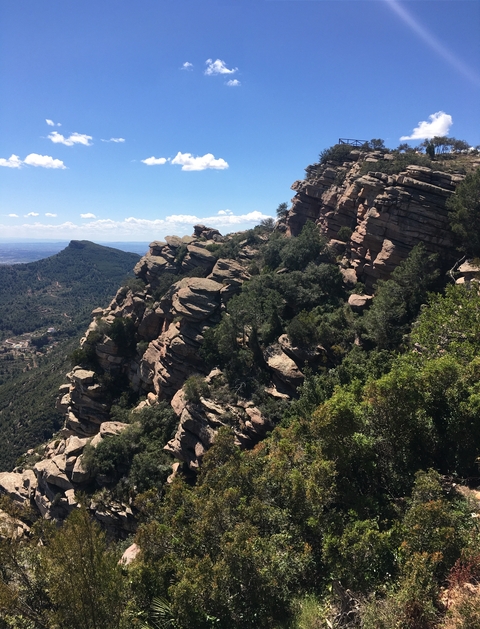 Rocky landscape with jagged cliffs and scattered trees.
