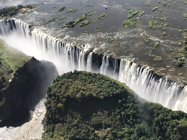       Aerial view of Victoria Falls with water cascading.
  