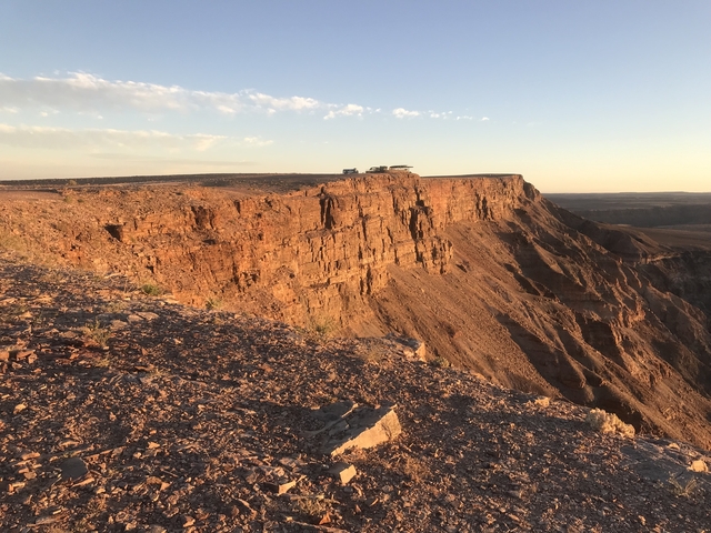       Rock cliff with cloudy sky in background.
  