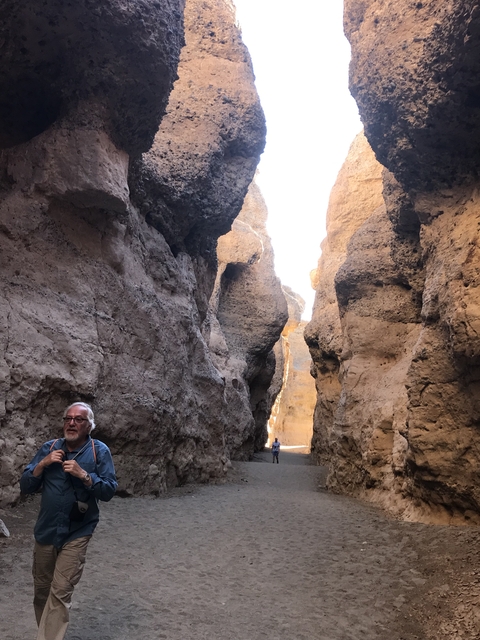       Person in front of a narrow canyon.
  