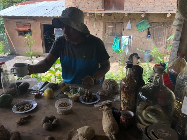 Person surrounded by various natural products at a market table.