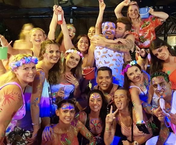 Group of people at a nighttime party with glow paint.