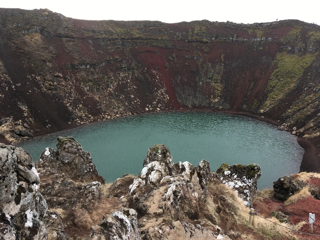       Crater lake surrounded by rugged cliffs.
  