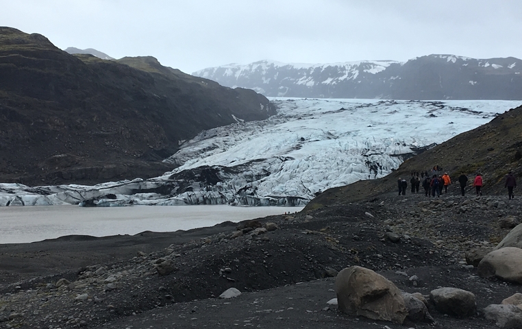       Hikers approaching a glacier.
  
