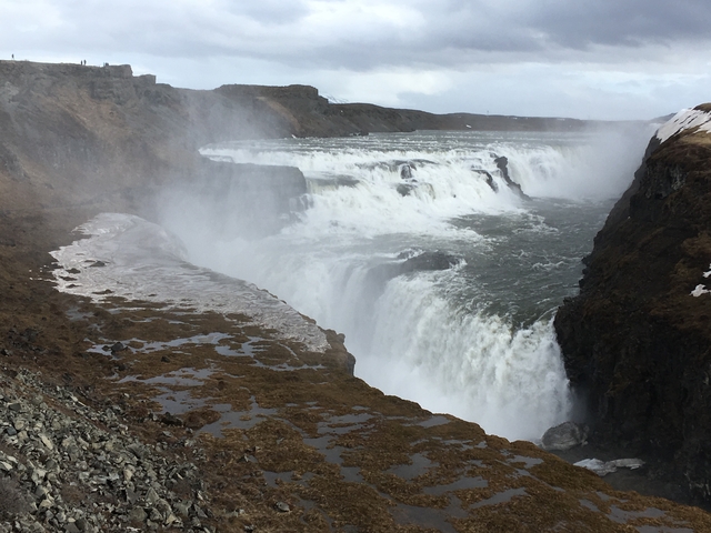       Powerful waterfall with mist and cliffs.
  