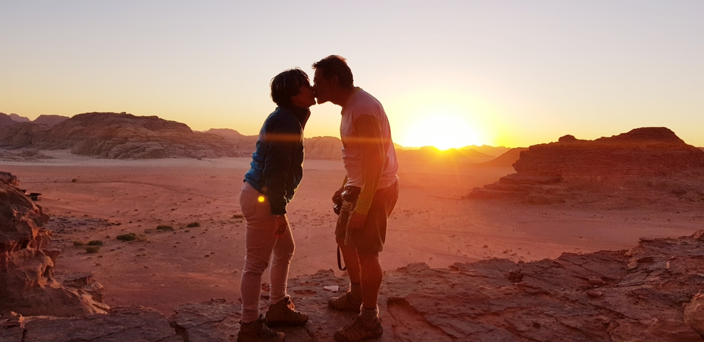 Couple kissing at sunset in the desert.