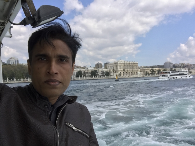 Person on a boat with a cityscape in the background