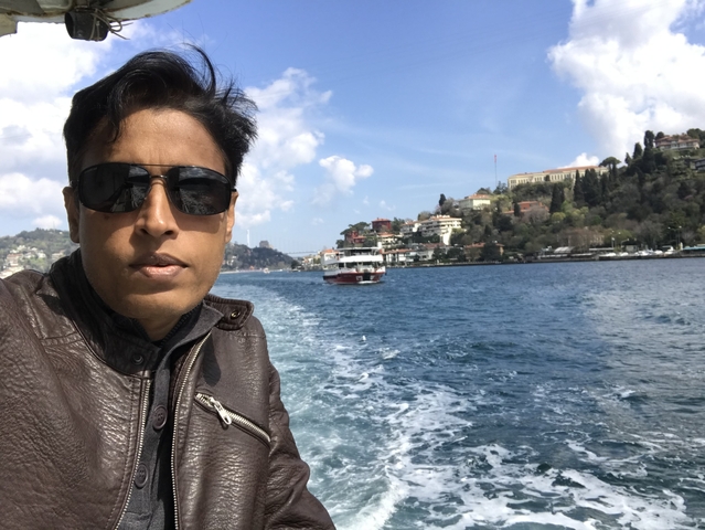 Person on a boat with cityscape and sea in the background