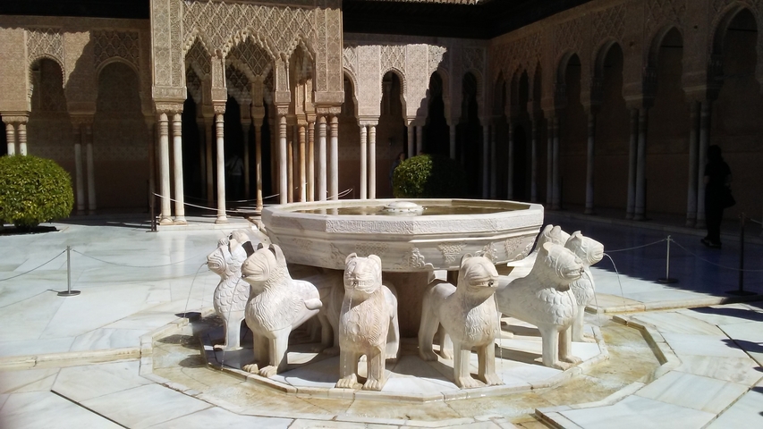 Stone fountain with lion statues in a courtyard.