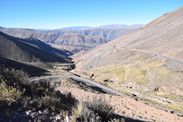 Wide shot of a winding mountain road through rocky terrain.