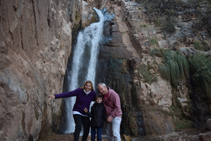 Family posing in front of a waterfall.