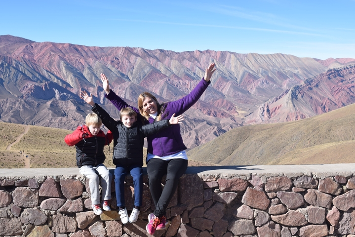 Family posing with dramatic mountain ranges in the background.