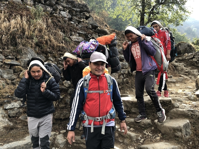Group of people trekking along a mountainous trail.