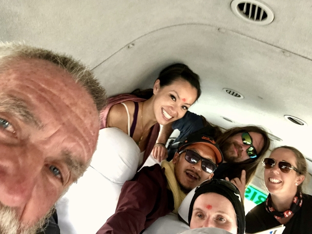 Group of people inside a small aircraft, smiling for the camera.