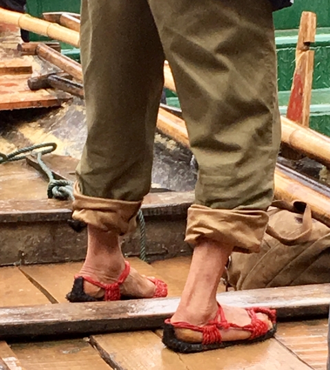 Close-up of pants with cuffs and bare feet.