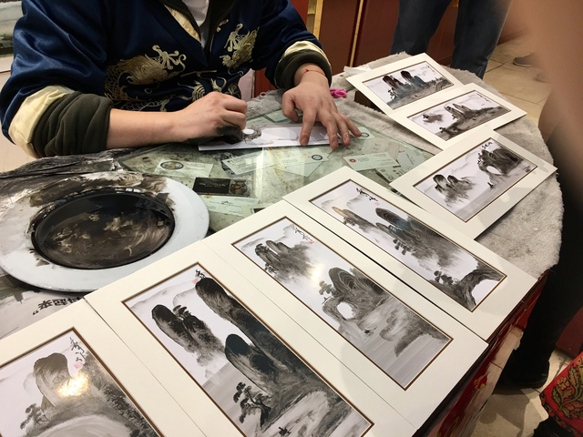 Close-up of a person's hands painting art.
