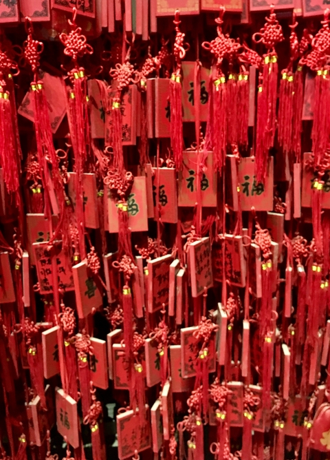 Wooden charms with red tassels hanging.