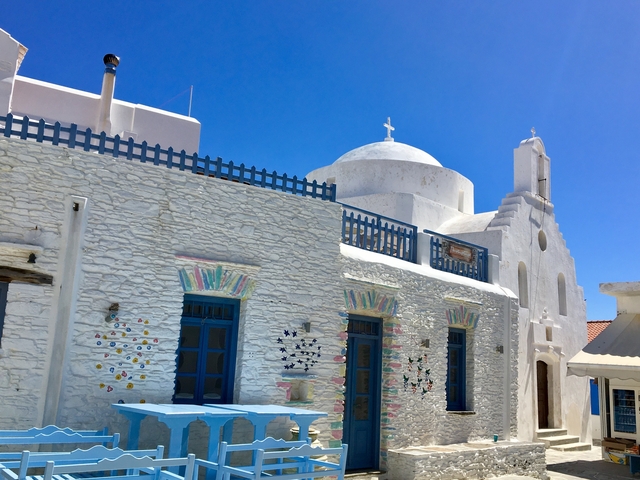White stone building with colorful window decorations and a dome on top.
