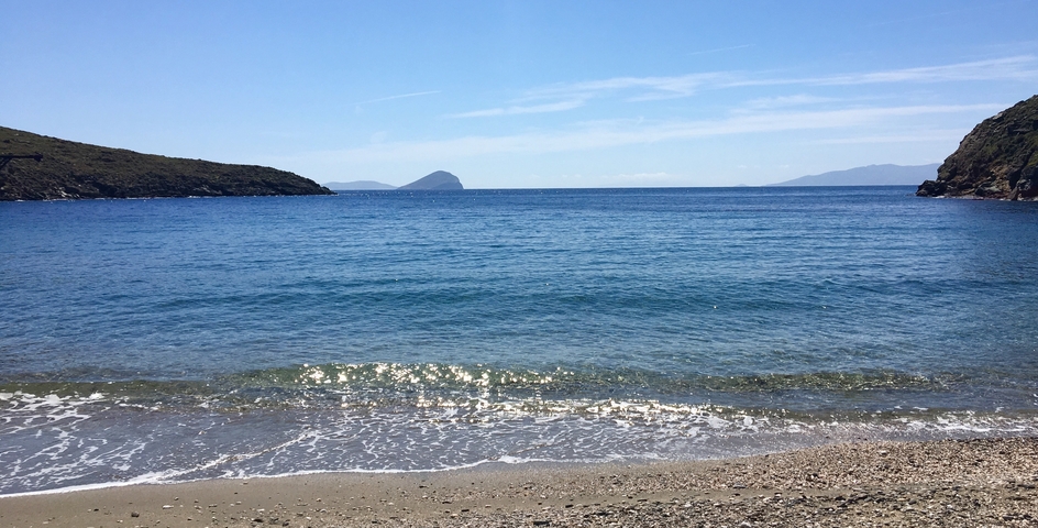 Calm sea view with hills and a distant island.