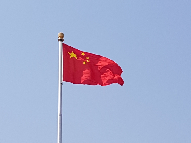 Chinese national flag flying on a pole.