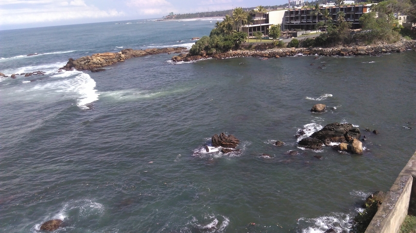 A rocky seashore with waves hitting the rocks.