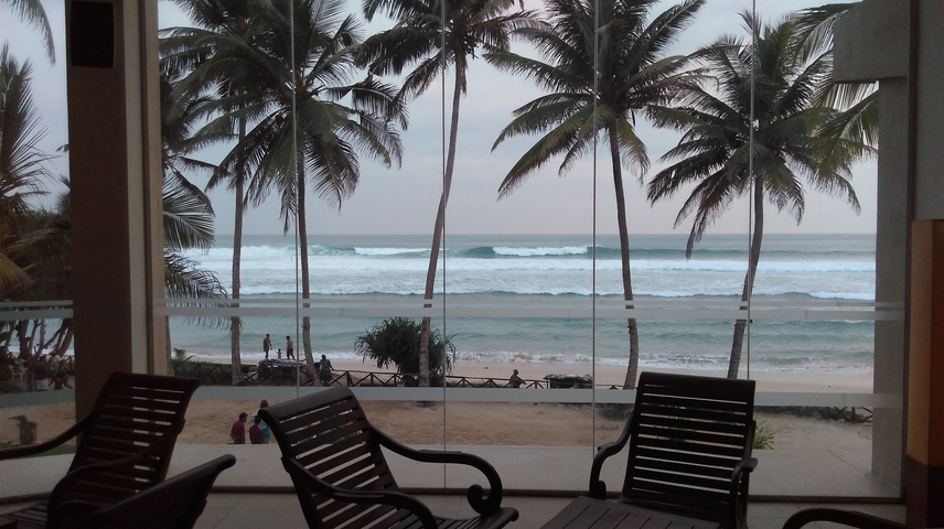 Indoor view of the beach through glass windows.