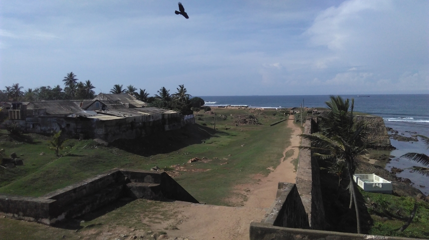 A coastal fort area with greenery and ocean views.