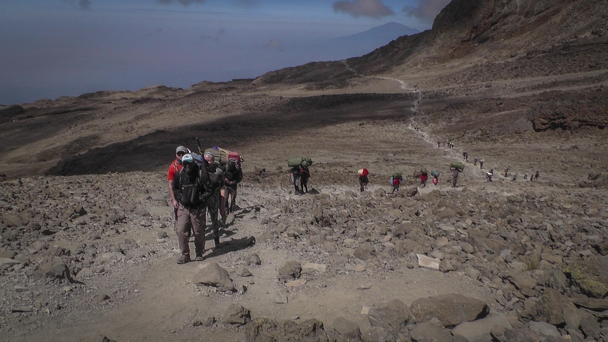       Hikers trekking on a mountainous path.
  