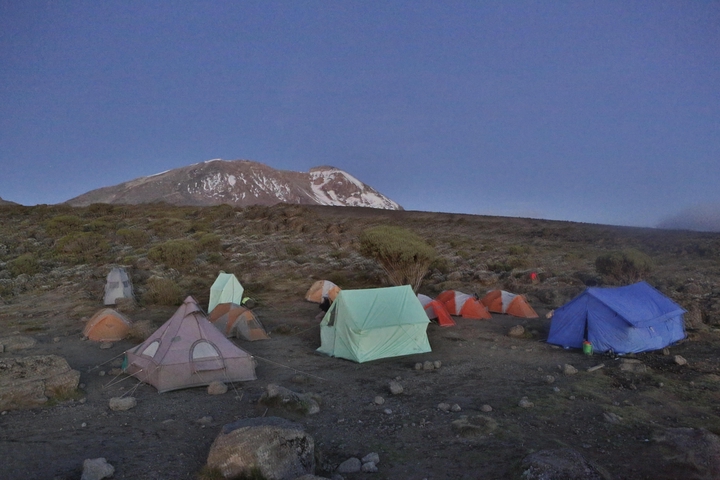       Camping tents set against a mountain backdrop.
  