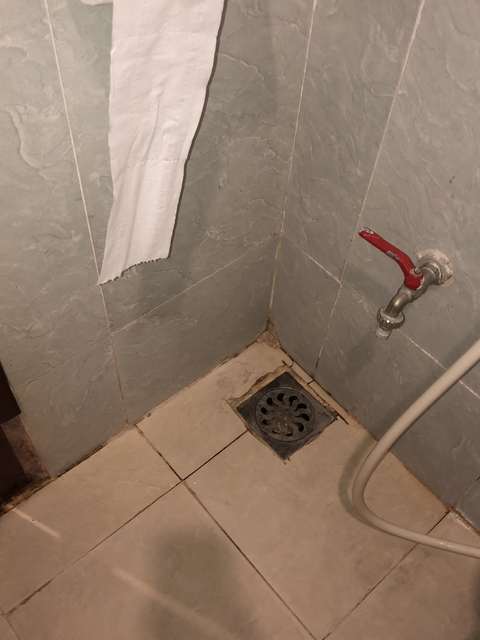       Bathroom corner with a towel and plumbing fixtures.
  