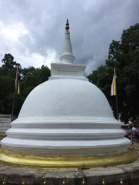 White-painted stupa surrounded by flags.