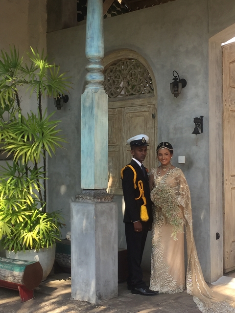 Portrait of a couple in traditional attire in front of a wooden door.
