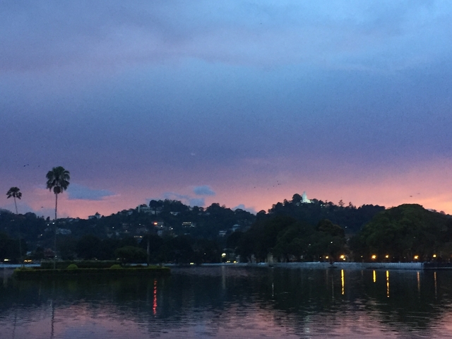 Sunset over a city with a lake view.